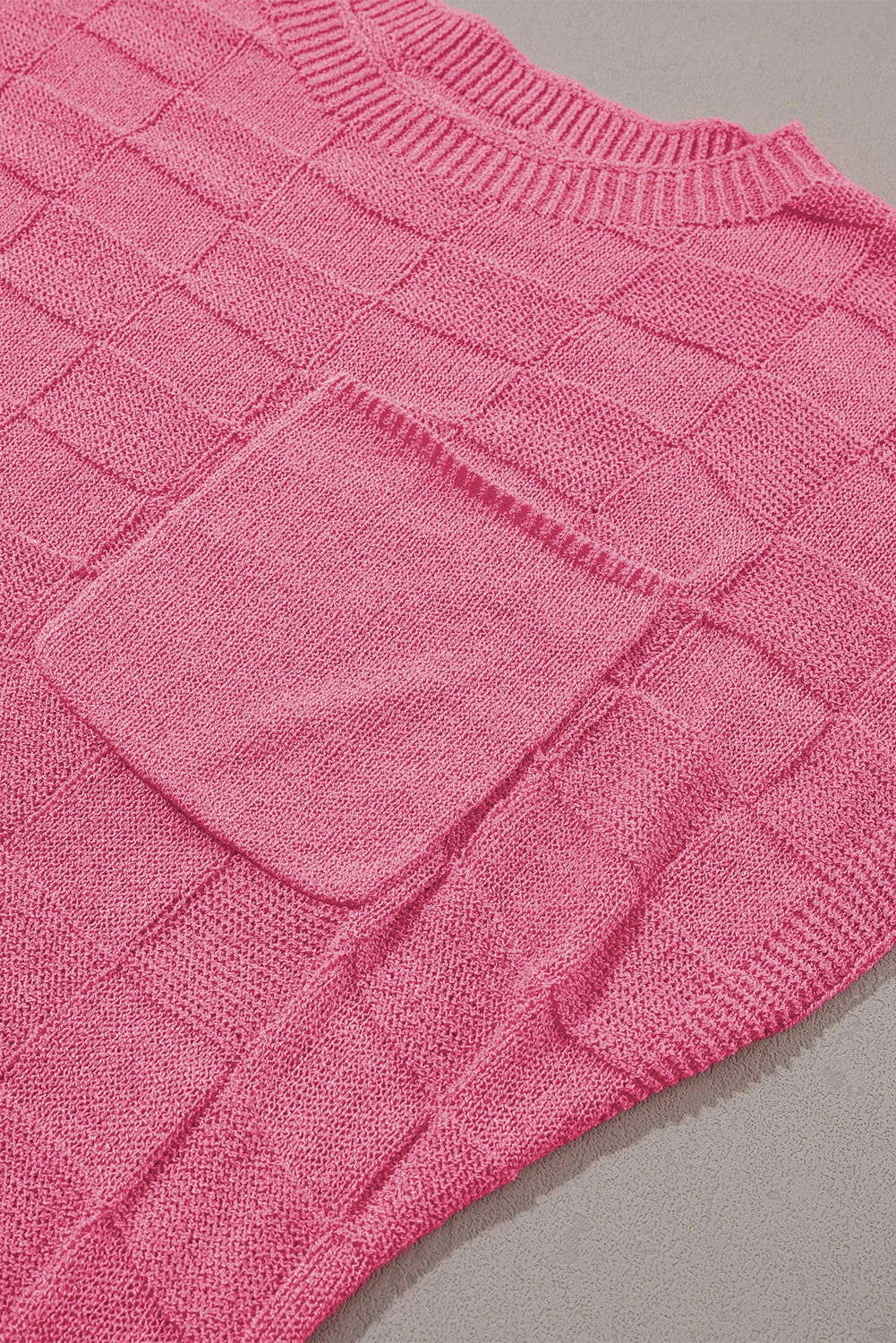 Leuchtend rosafarbener strickpullover mit kurzen ärmeln und gitterstruktur