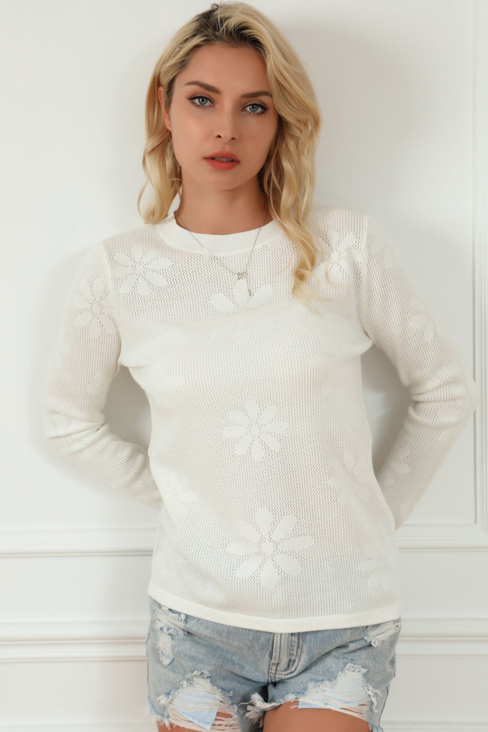 Weißer blumenstrickpullover mit langen ärmeln