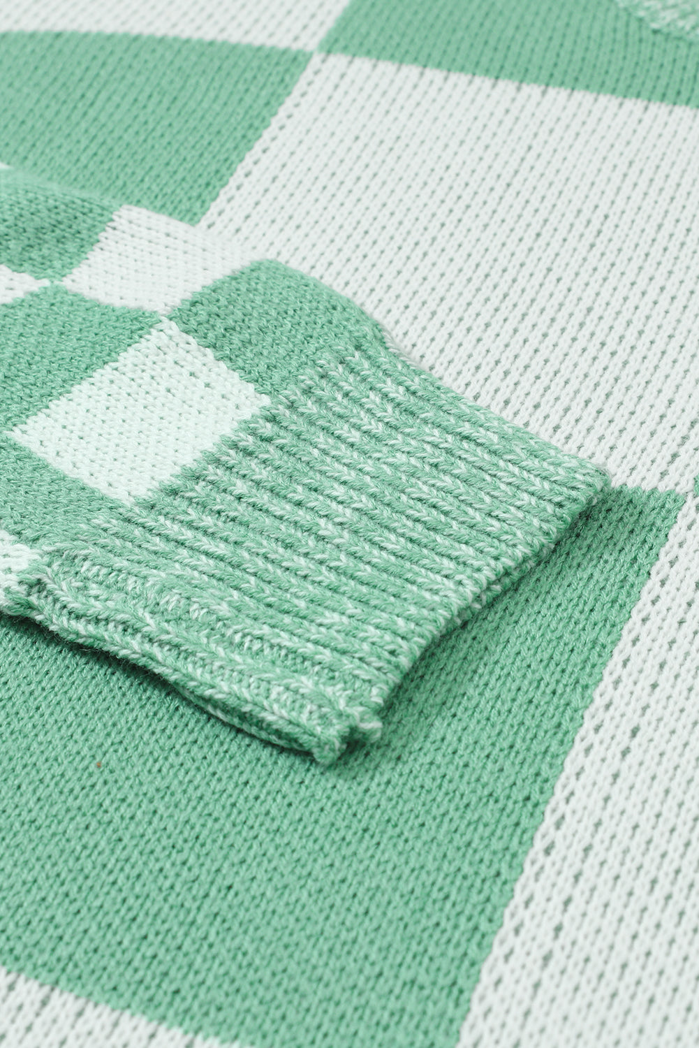Mintgrüner pullover mit karomuster und schultertaschen