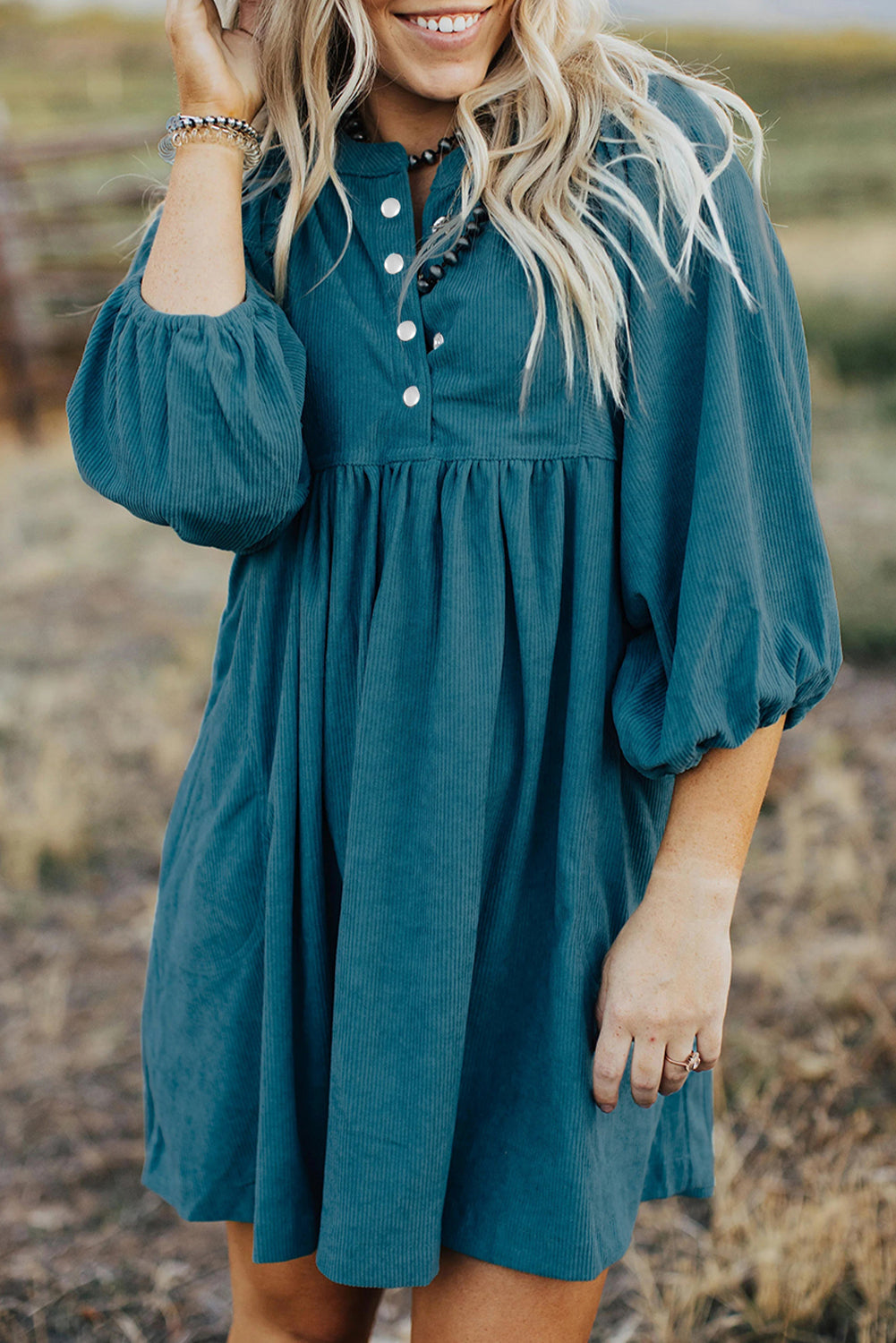 Blaues cord-knopf-kleid mit empire-taille und armband-ärmeln
