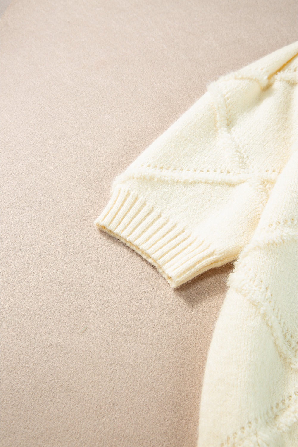 Weißer kurzarmpullover mit rautenmuster und gerippten abschlüssen