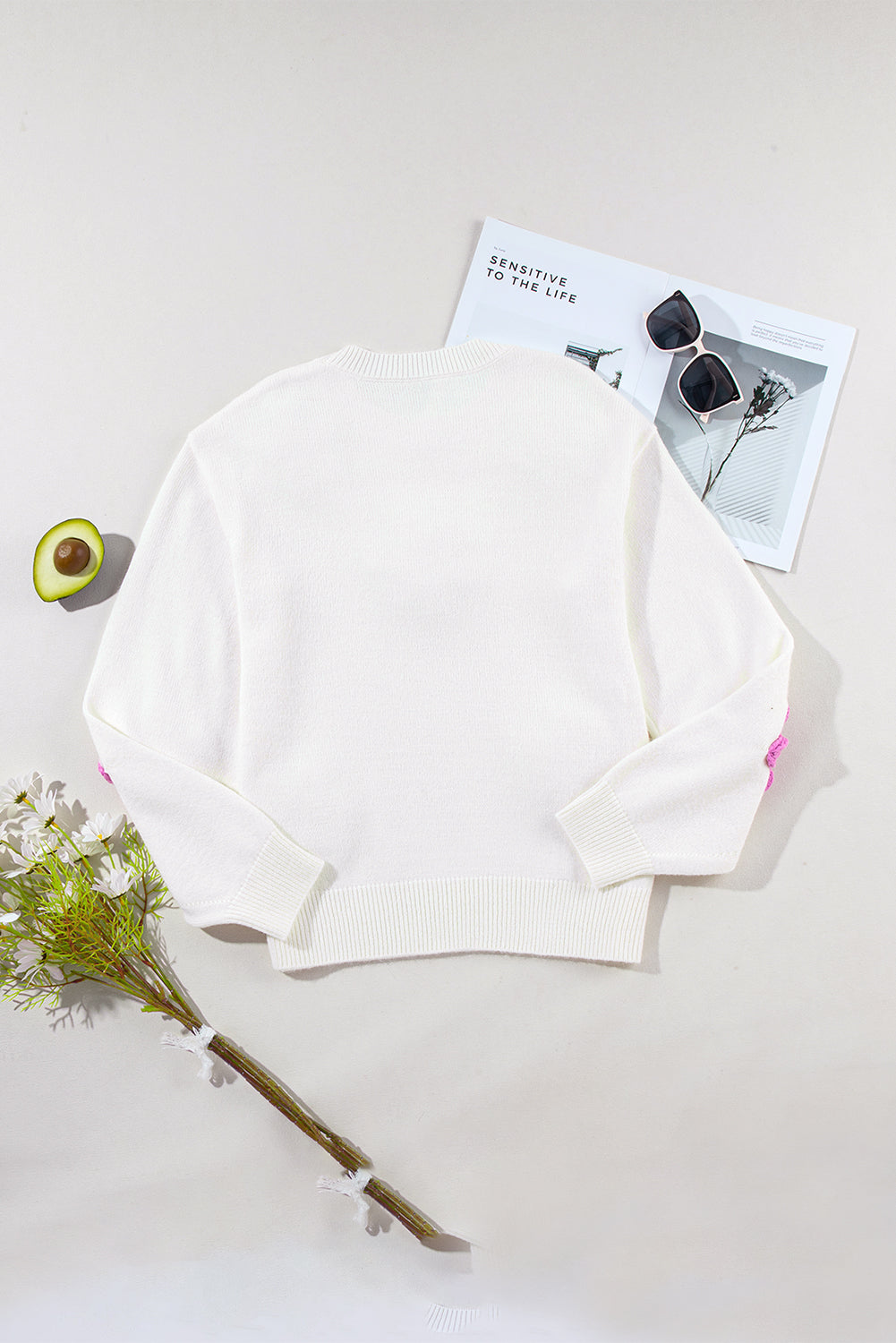 Weißer gehäkelter grobstrickpullover mit blumenmuster