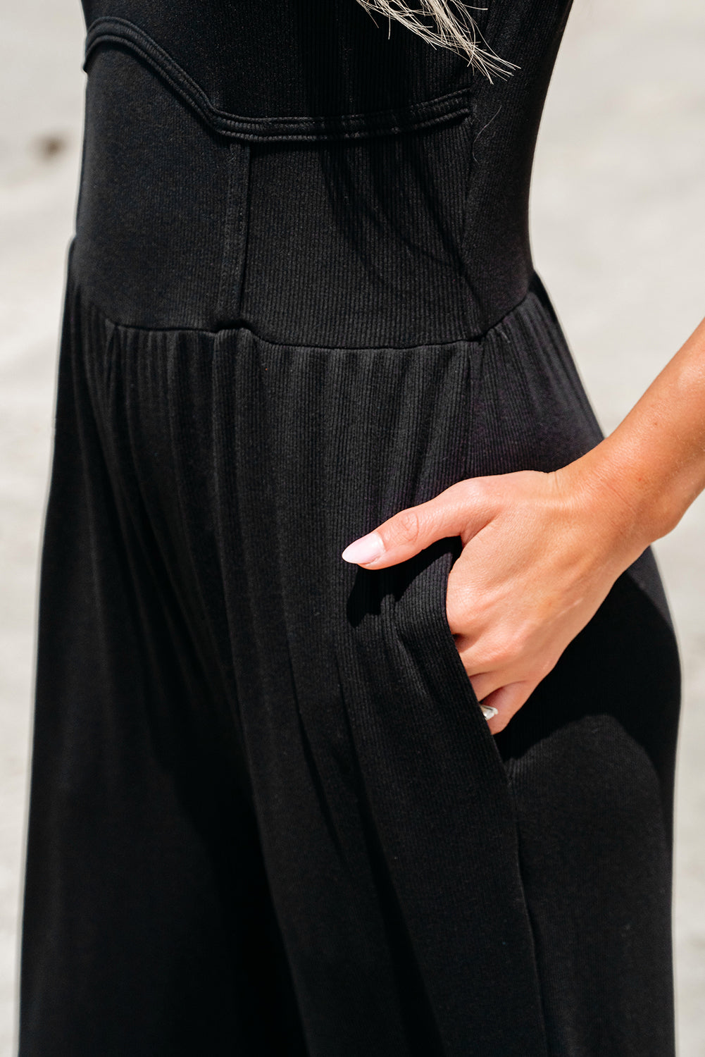 Schwarzer ärmelloser jumpsuit mit weitem bein und eingeschnürter taille