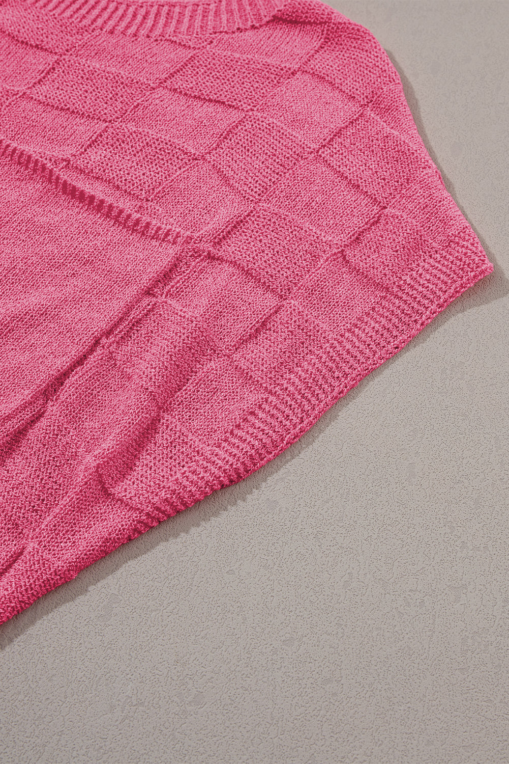 Leuchtend rosafarbener strickpullover mit kurzen ärmeln und gitterstruktur