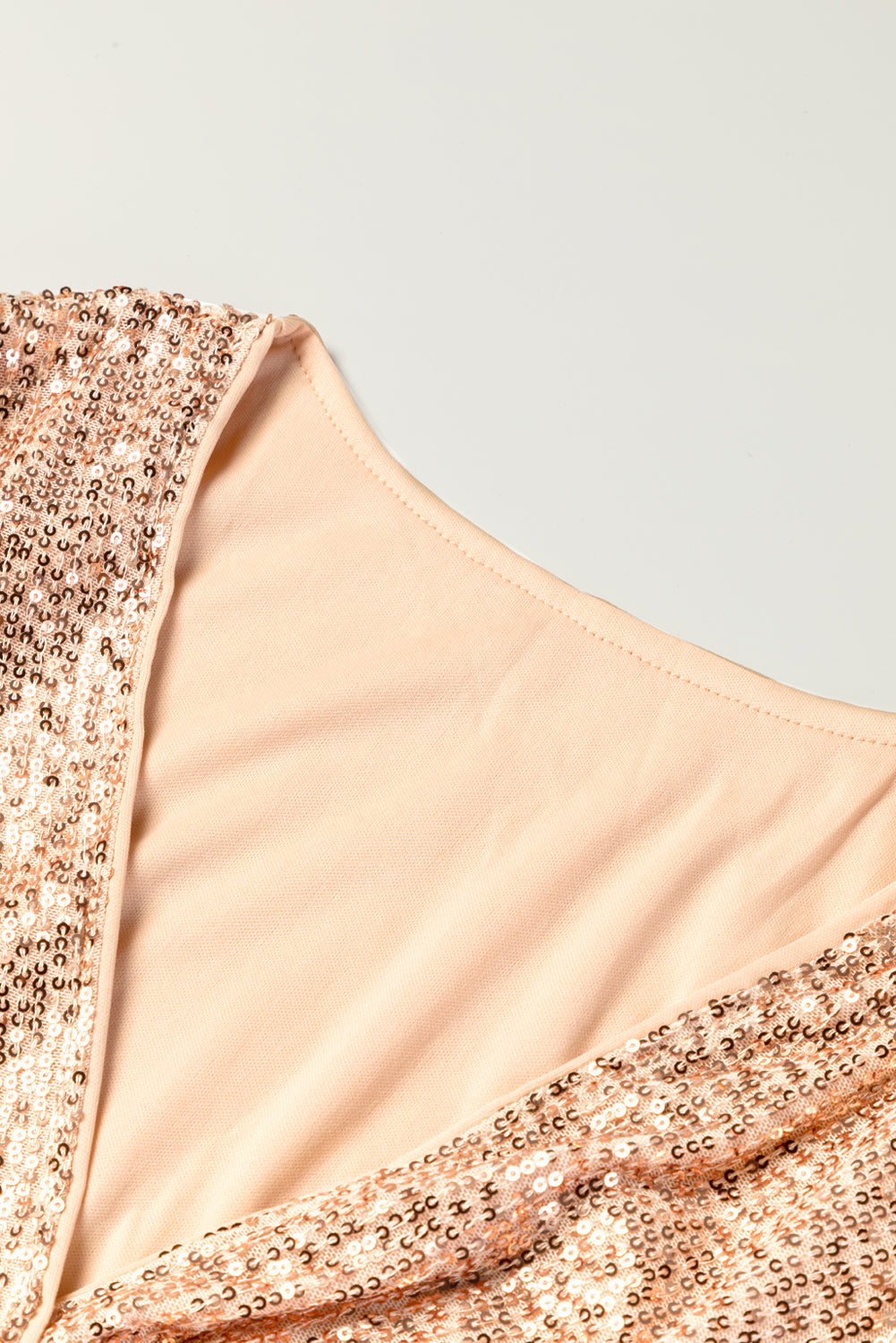 Aprikosenfarbenes wickelkleid mit v-ausschnitt und pailletten
