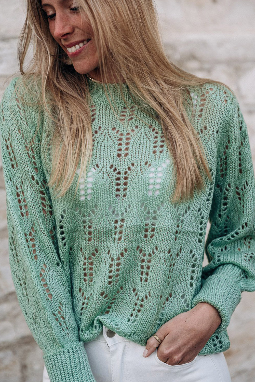 Grüner pointelle-pullover aus transparentem strick