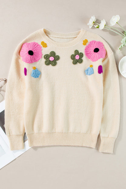Beige gestrickter pullover mit blumenmuster und geripptem rand