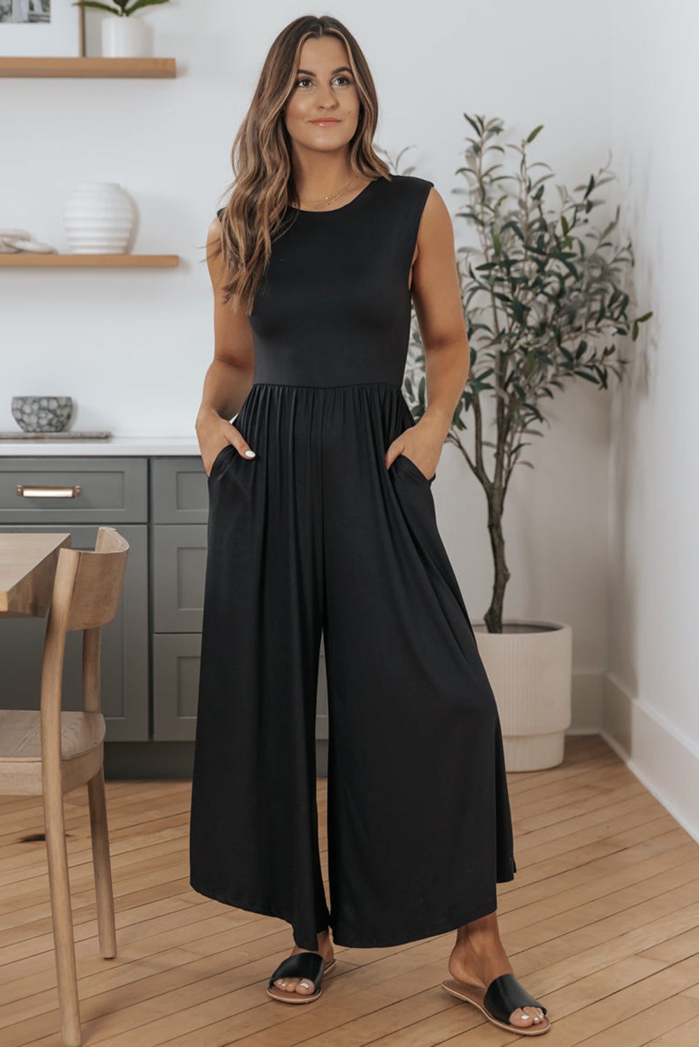 Schwarzer jumpsuit mit weitem bein und offenem rücken