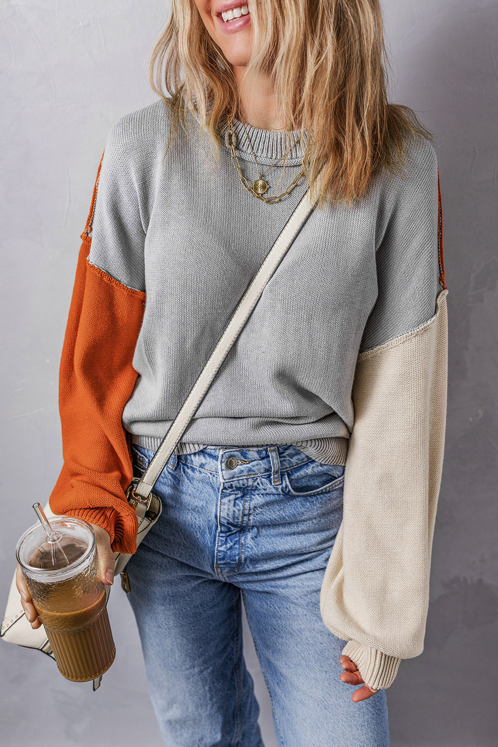 Grauer colorblock-pullover mit gerippten ärmeln und zierleisten