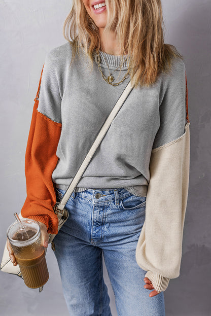 Grauer colorblock-pullover mit gerippten ärmeln und zierleisten