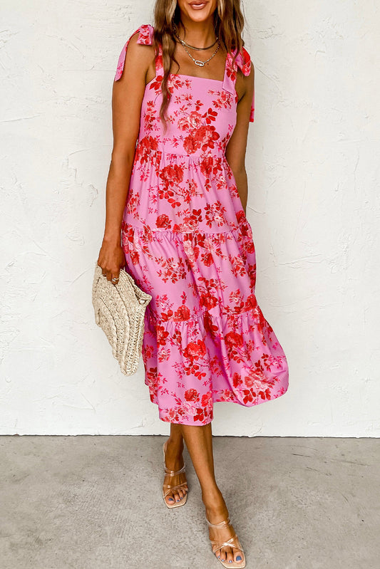 Rosa kleid mit gestuften blumenträgern und krawattenschultern
