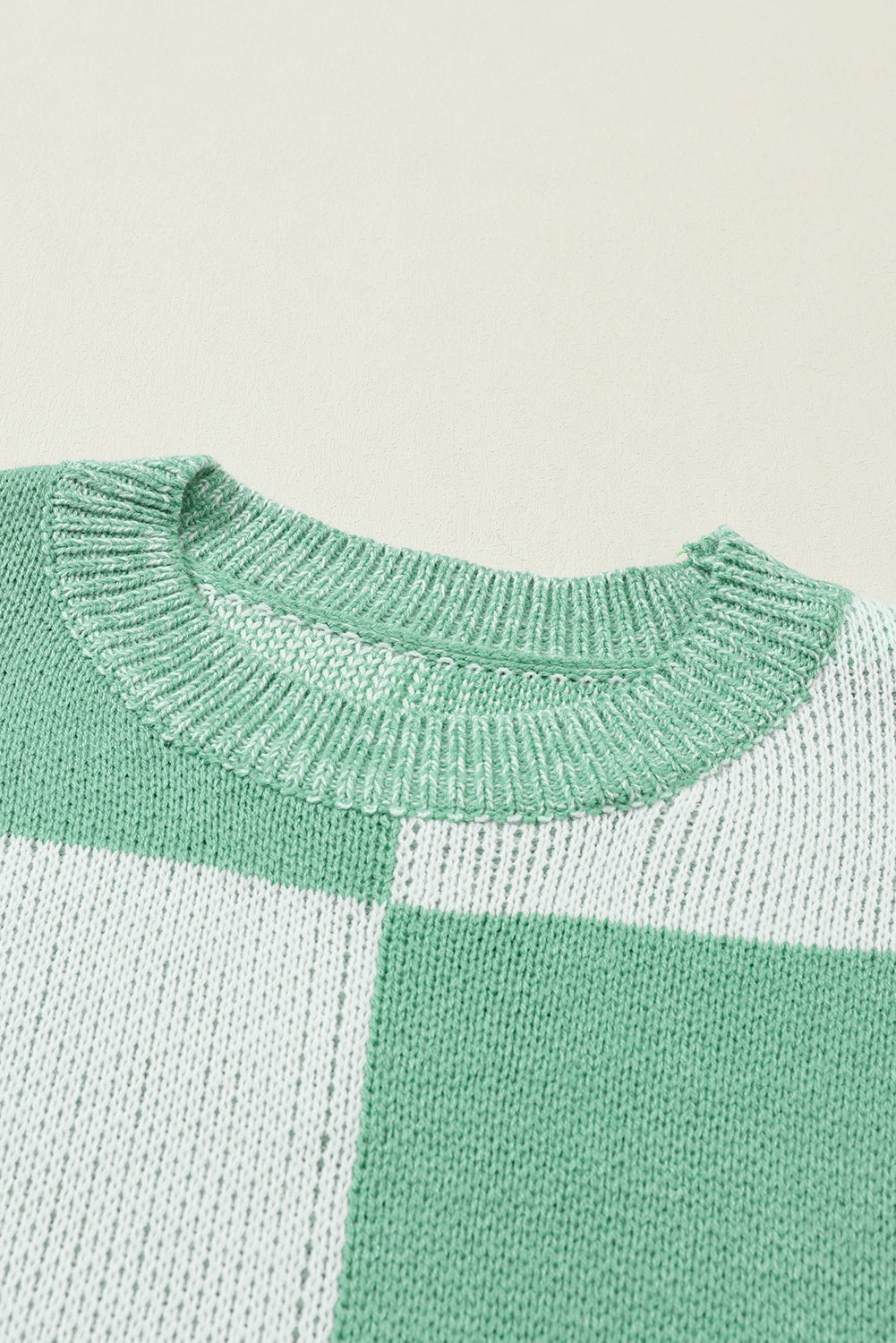 Mintgrüner pullover mit karomuster und schultertaschen