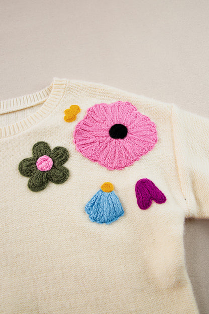 Beige gestrickter pullover mit blumenmuster und geripptem rand