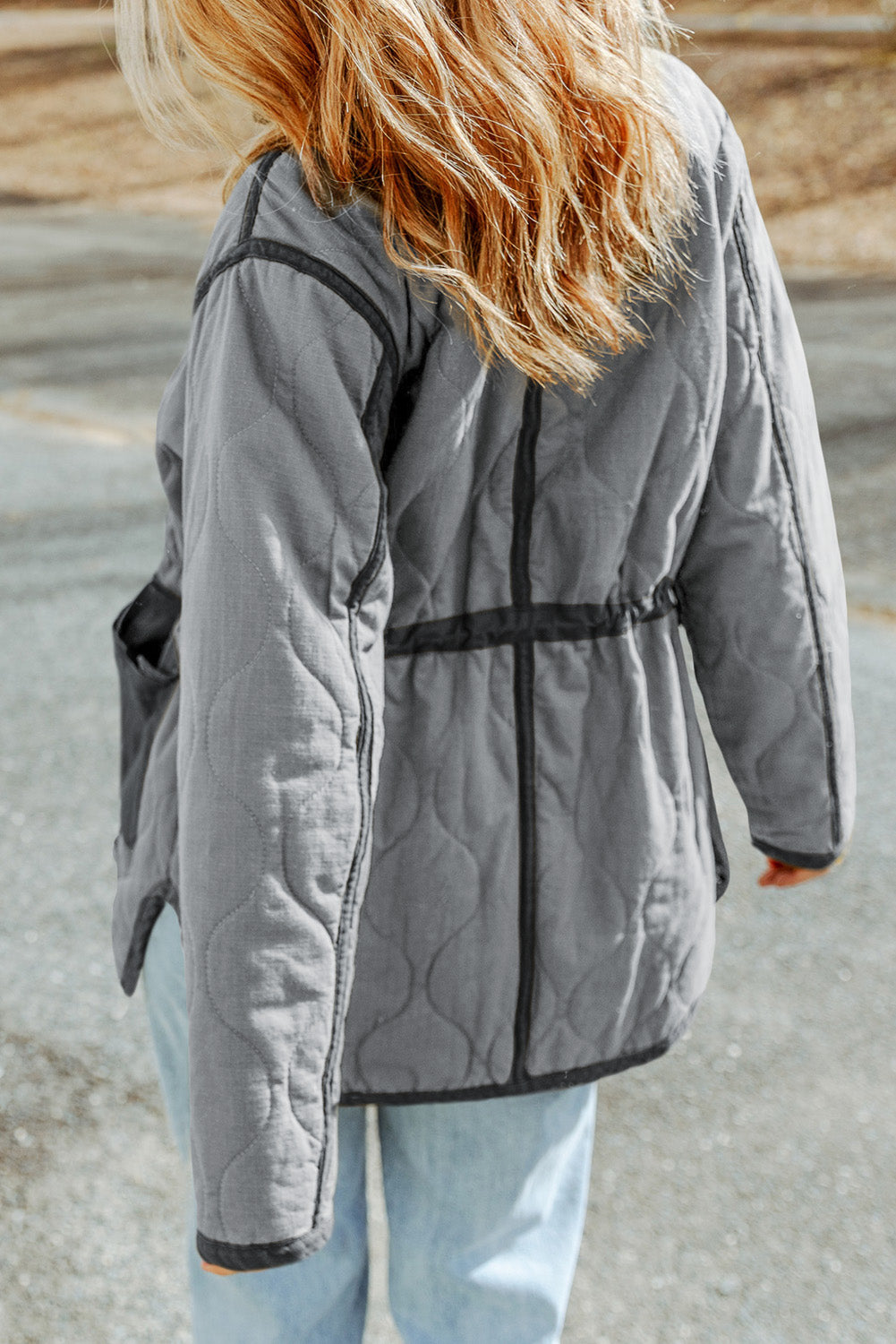 Steppjacke mit kordelzug und grauen steppnähten