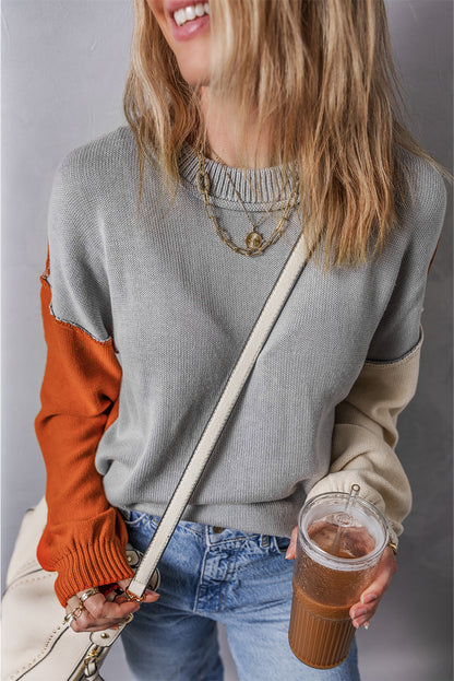 Grauer colorblock-pullover mit gerippten ärmeln und zierleisten