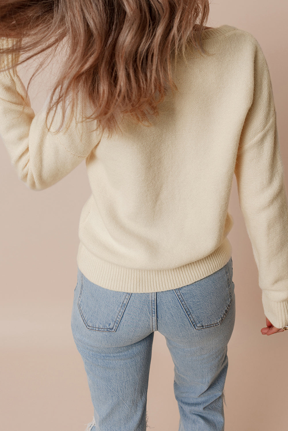 Beige gestrickter pullover mit blumenmuster und geripptem rand