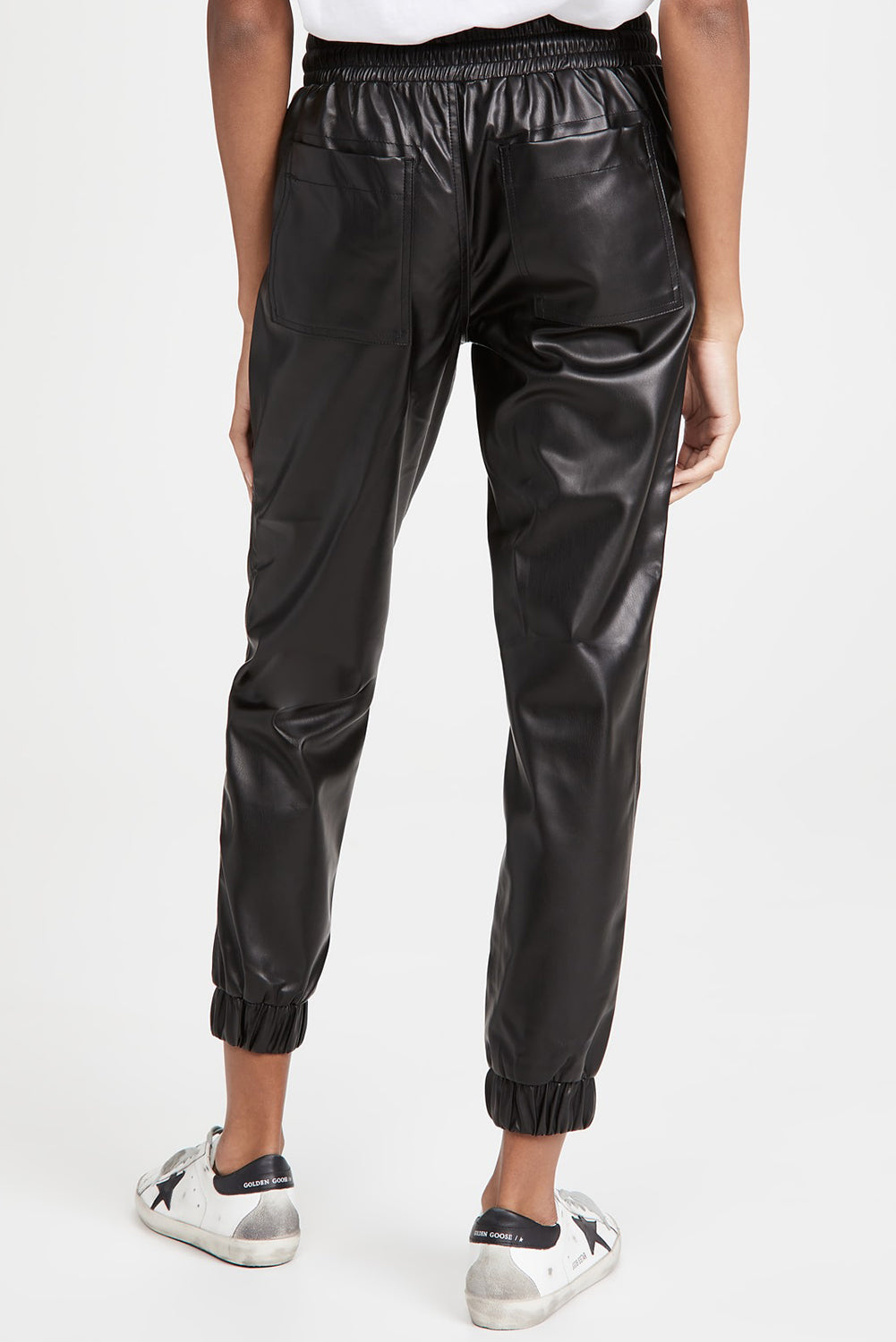 Schwarze kunstleder-jogginghose mit gesmokter taille und kordelzug