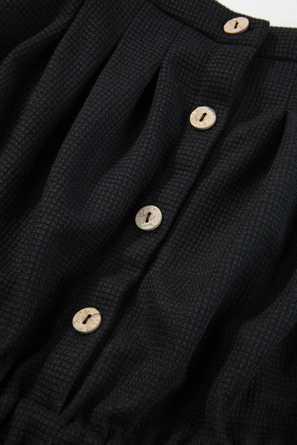 Schwarzer jumpsuit mit geknoteten trägern und strukturiertem kordelzug