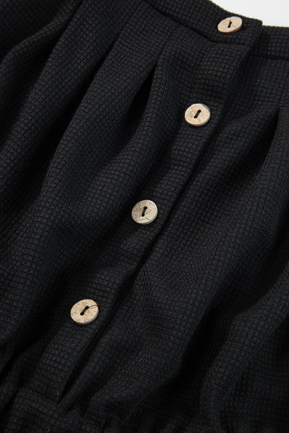 Schwarzer jumpsuit mit geknoteten trägern und strukturiertem kordelzug