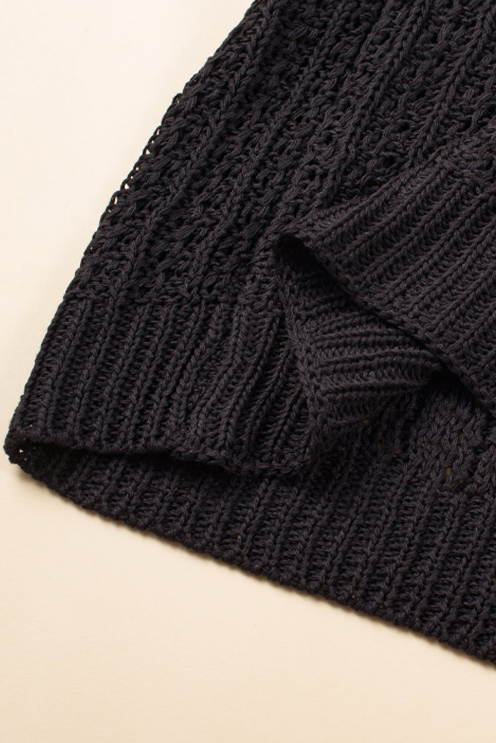 Schwarze strickjacke mit ausgehöhlten armbändern und ärmeln