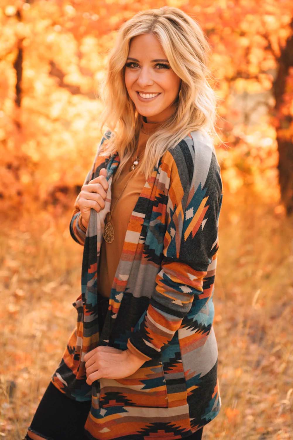 Orangefarbene strickjacke mit aztekischem stammesmuster