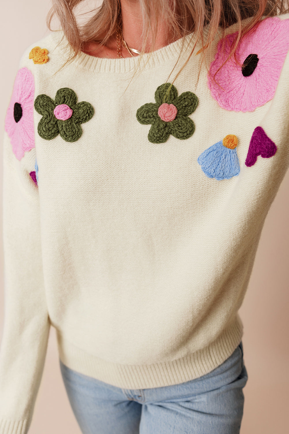 Beige gestrickter pullover mit blumenmuster und geripptem rand