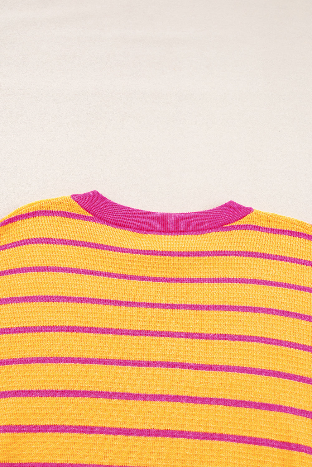Orangefarbener gestreifter pullover mit rundhalsausschnitt und losen schultern