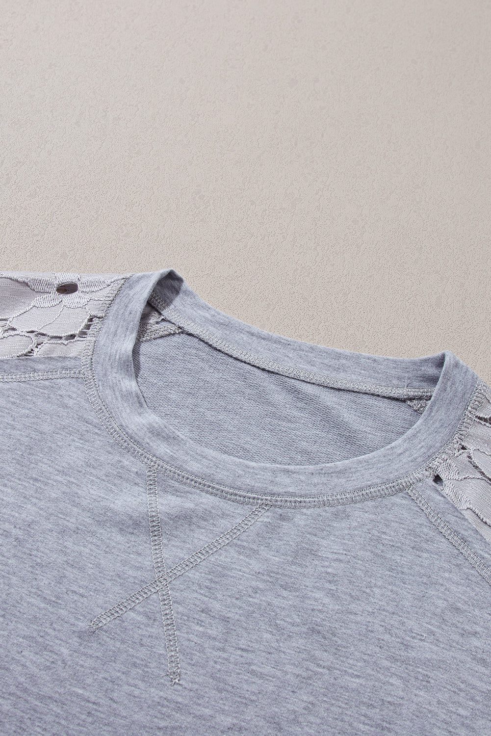 Hellgraues t-shirt-kleid mit floralem patchwork und rüschenbesatz aus spitze