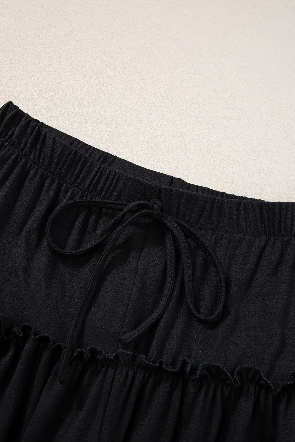 Schwarze gerüschte hose mit weitem bein und hoher taille mit kordelzug