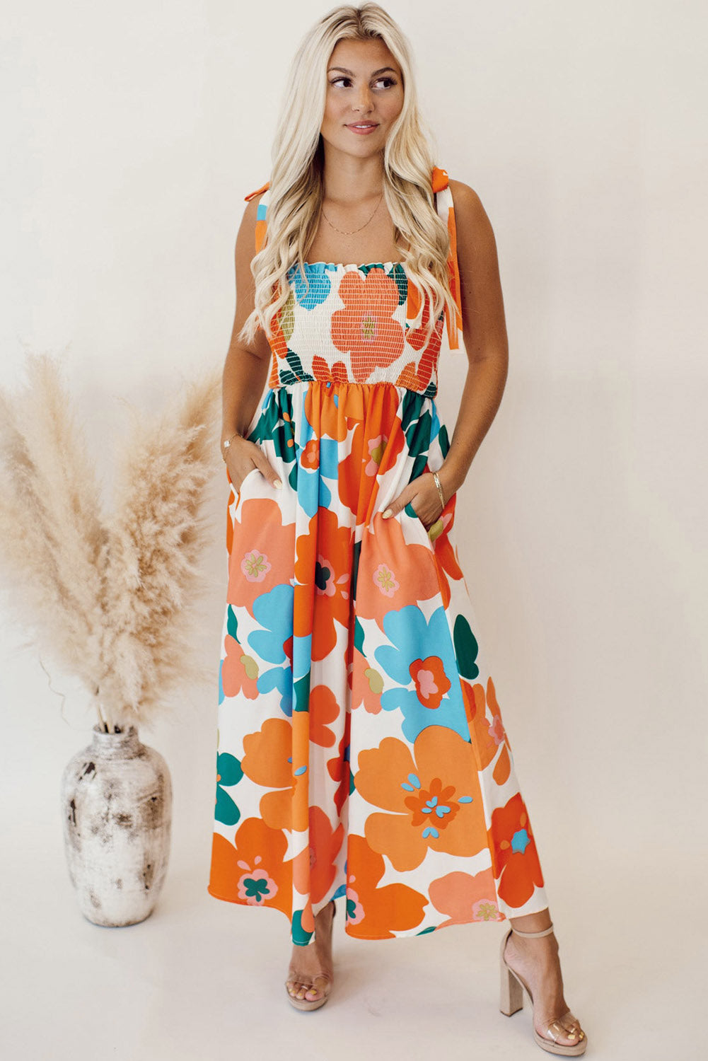 Orangefarbenes maxikleid mit selbstgebundenen trägern und gesmokter oberweite