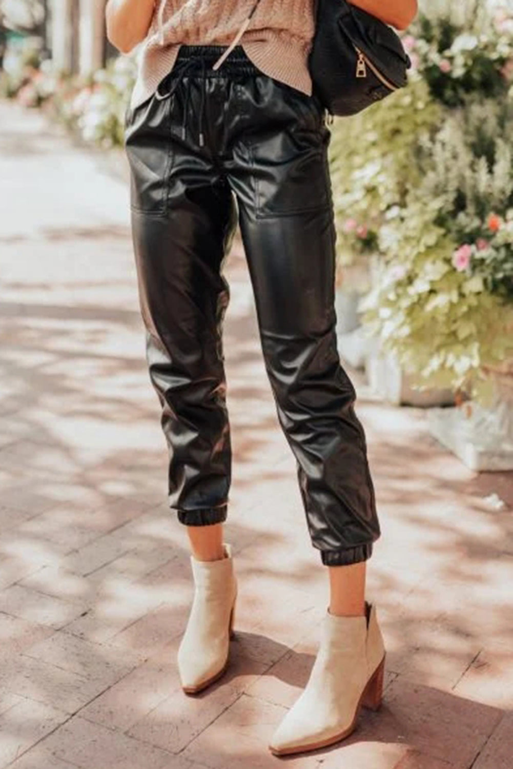 Schwarze kunstleder-jogginghose mit gesmokter taille und kordelzug