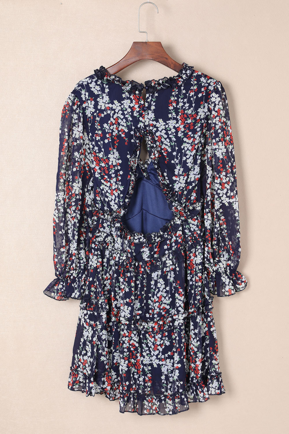 Blaues kleid mit rüschenbesatz und offenem rücken mit blumenmuster