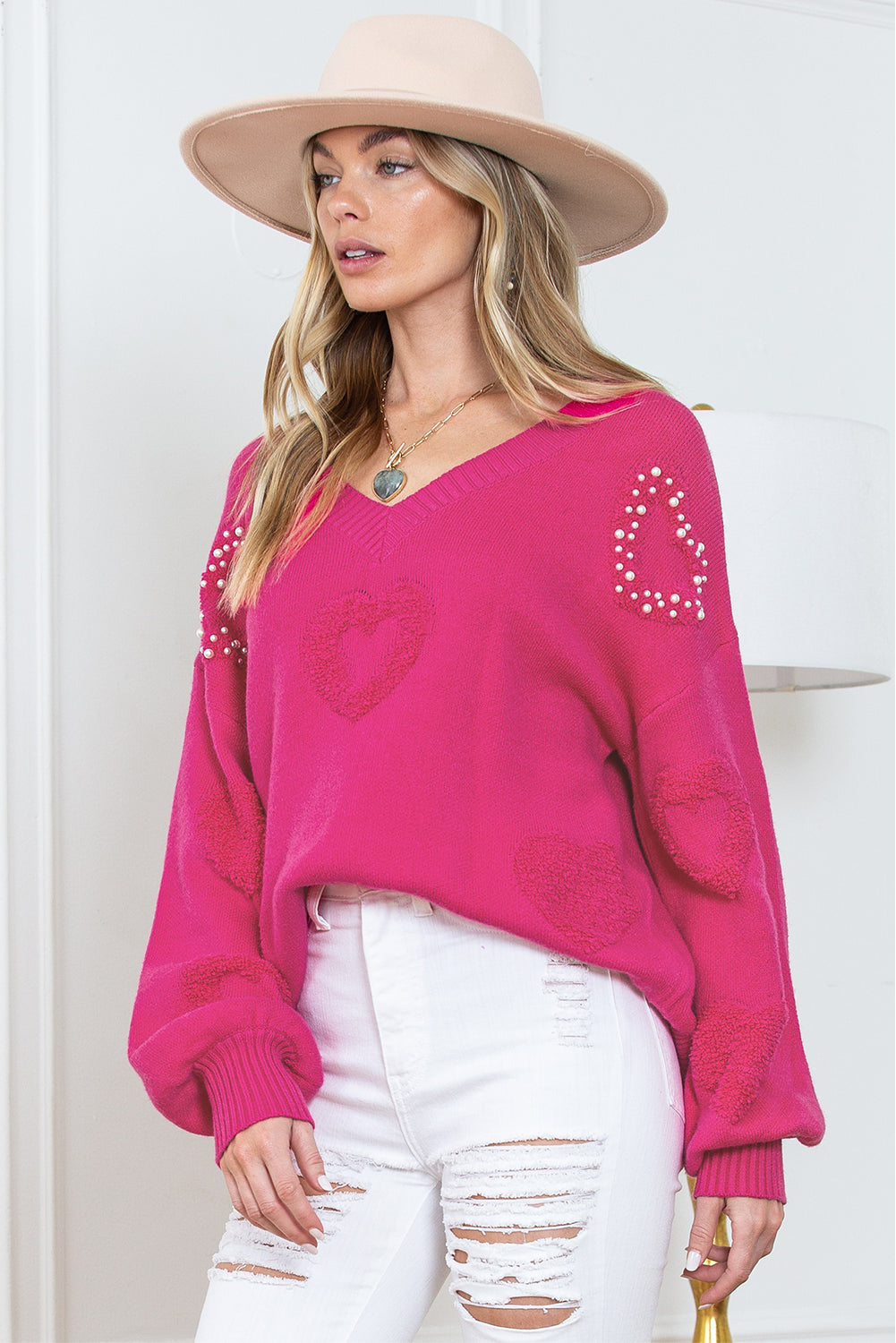 Rosenroter, perlenverzierter pullover mit v-ausschnitt und flauschigen herzen
