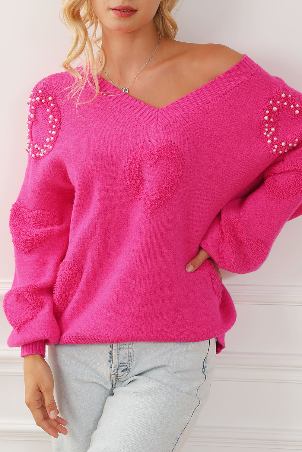 Rosenroter, perlenverzierter pullover mit v-ausschnitt und flauschigen herzen