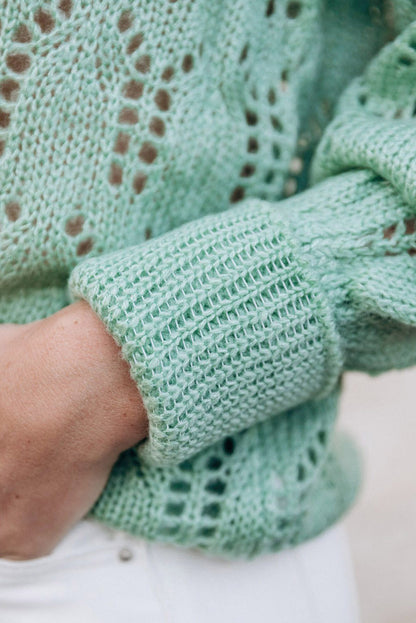 Grüner pointelle-pullover aus transparentem strick