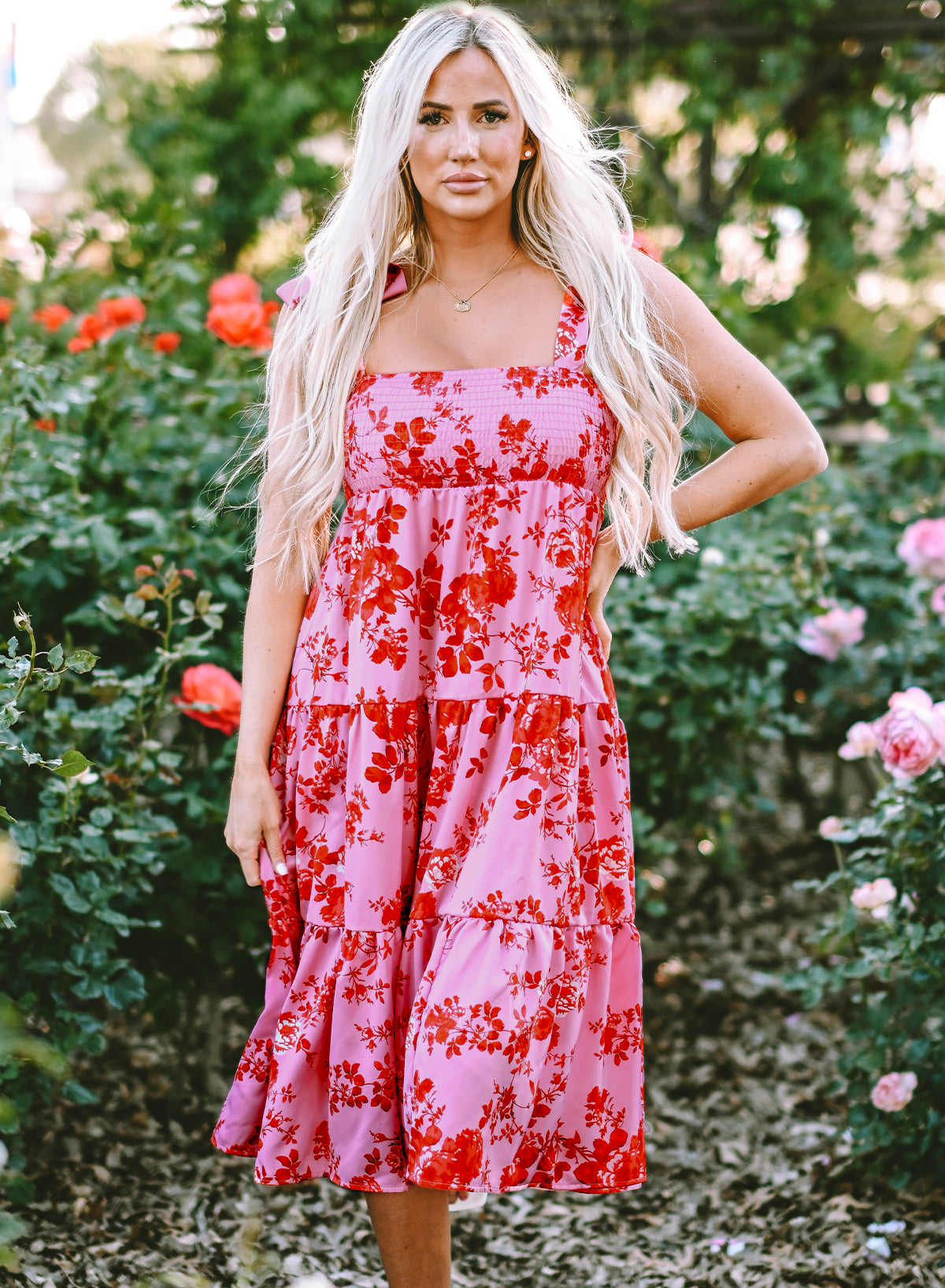 Rosa kleid mit gestuften blumenträgern und krawattenschultern