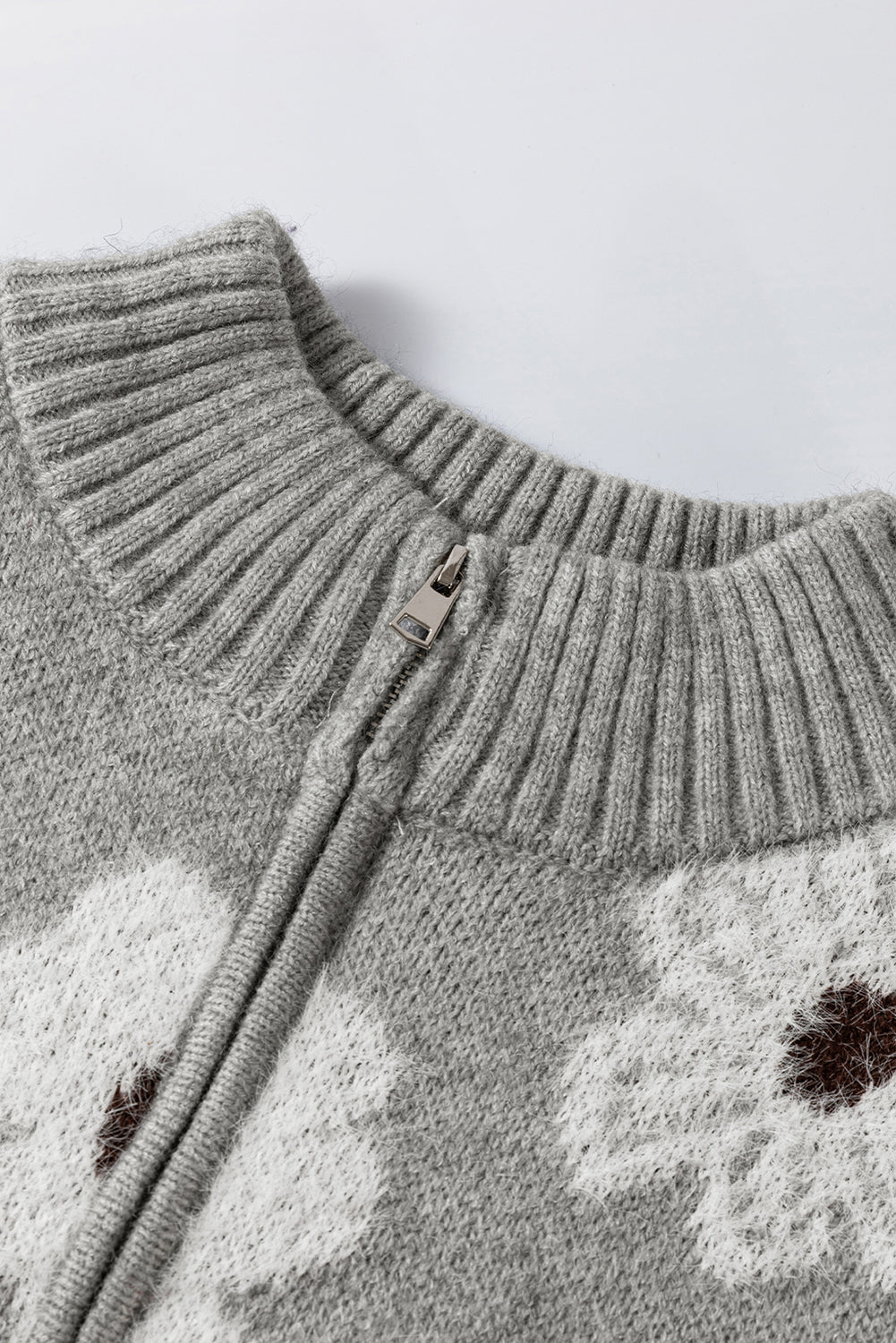 Grauer pullover mit floralem muster und halbem reißverschluss an der schulter