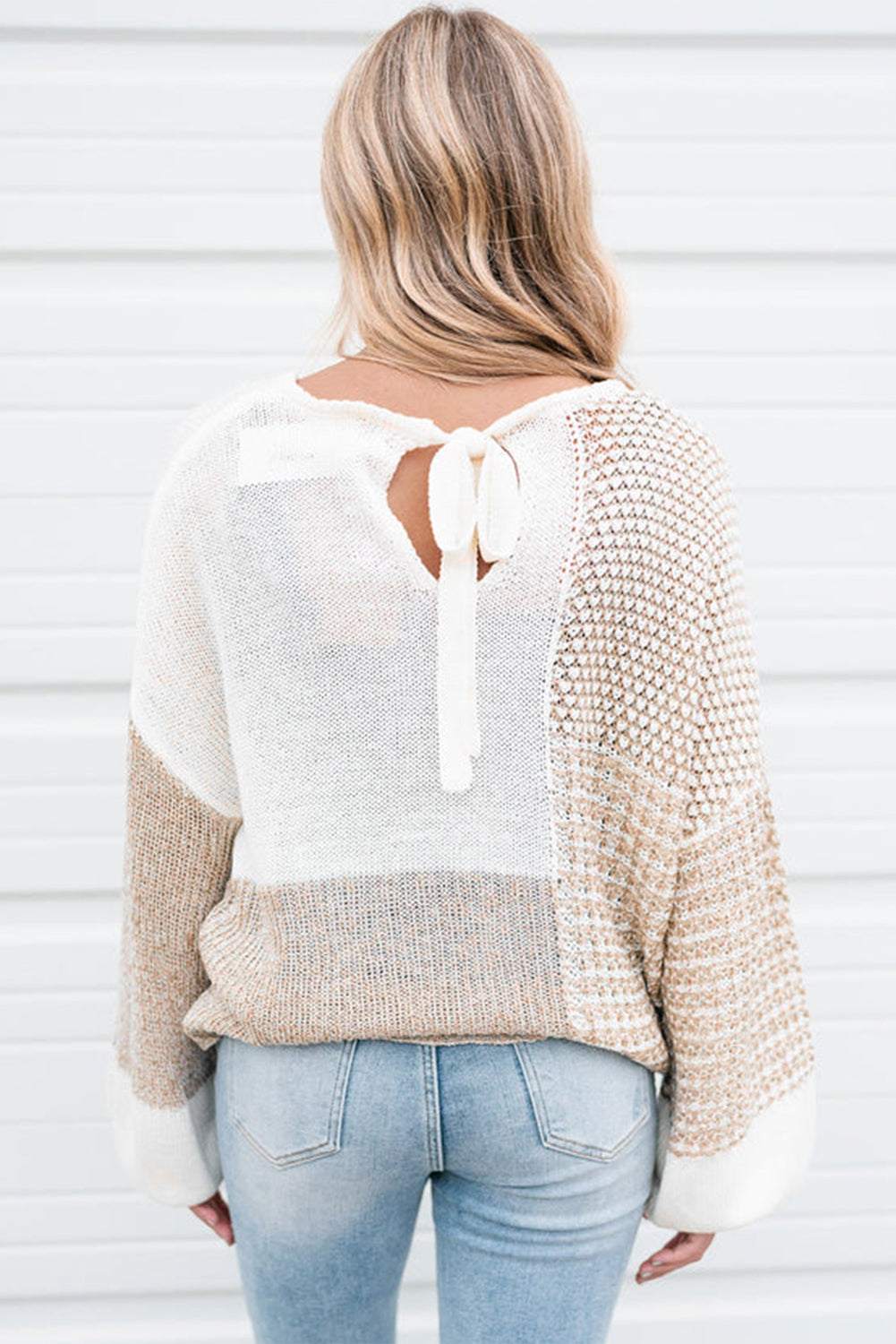 Haferflockenfarbener strickpullover mit gemischtem muster und schlüsselloch für die schultern
