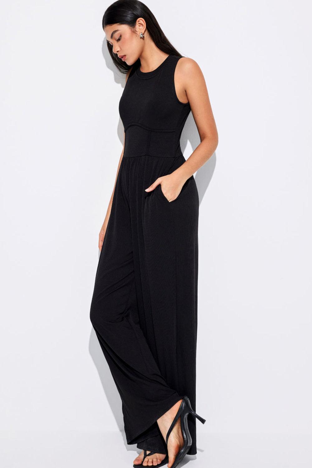 Schwarzer ärmelloser jumpsuit mit weitem bein und eingeschnürter taille