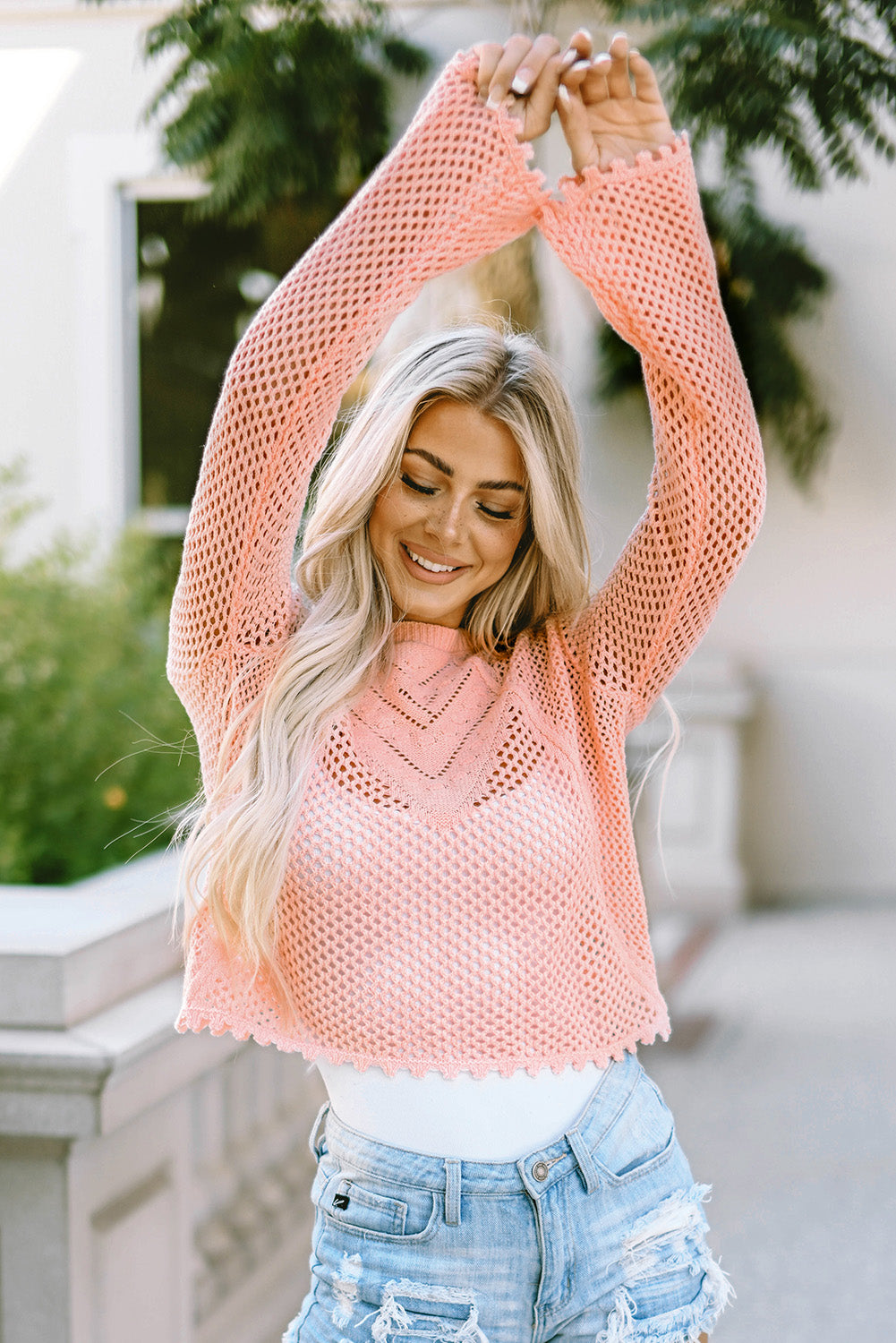 Rosa strickpullover mit glockenärmeln und hohlen ösen