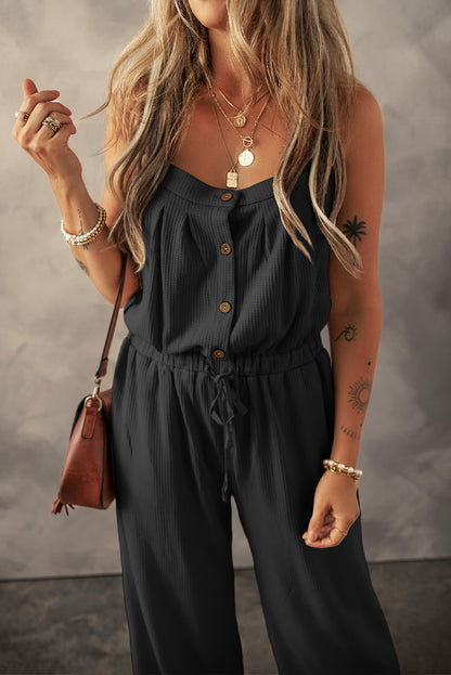 Schwarzer jumpsuit mit geknoteten trägern und strukturiertem kordelzug