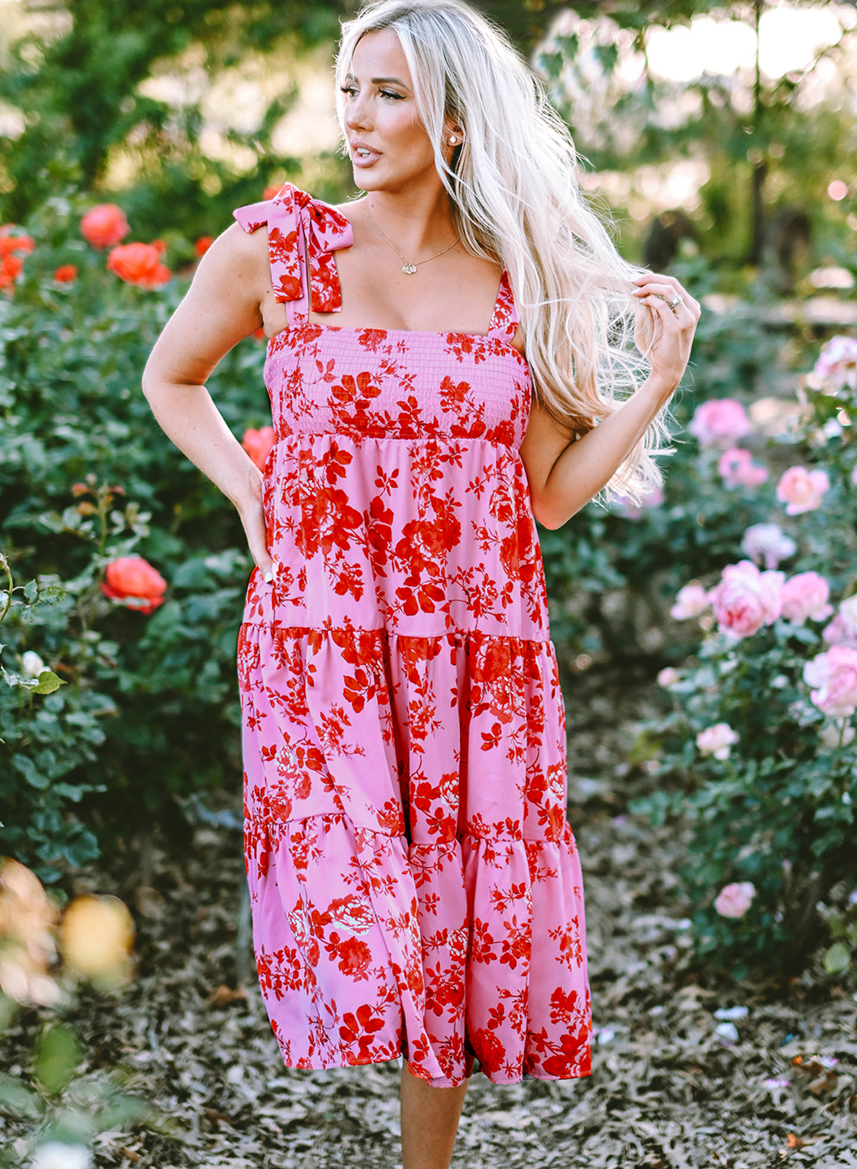 Rosa kleid mit gestuften blumenträgern und krawattenschultern