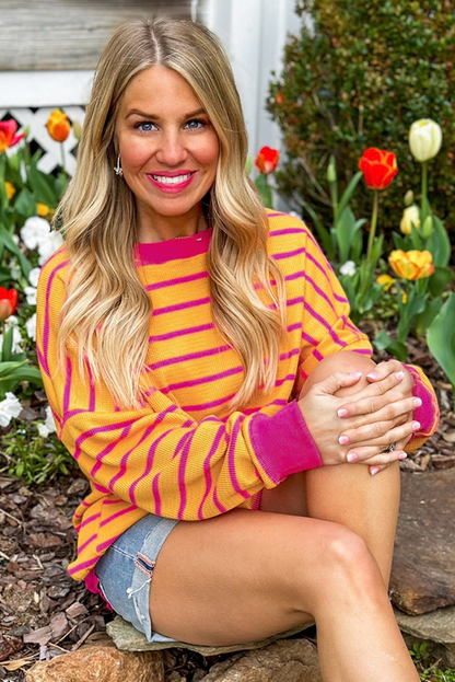 Orangefarbener gestreifter pullover mit rundhalsausschnitt und losen schultern