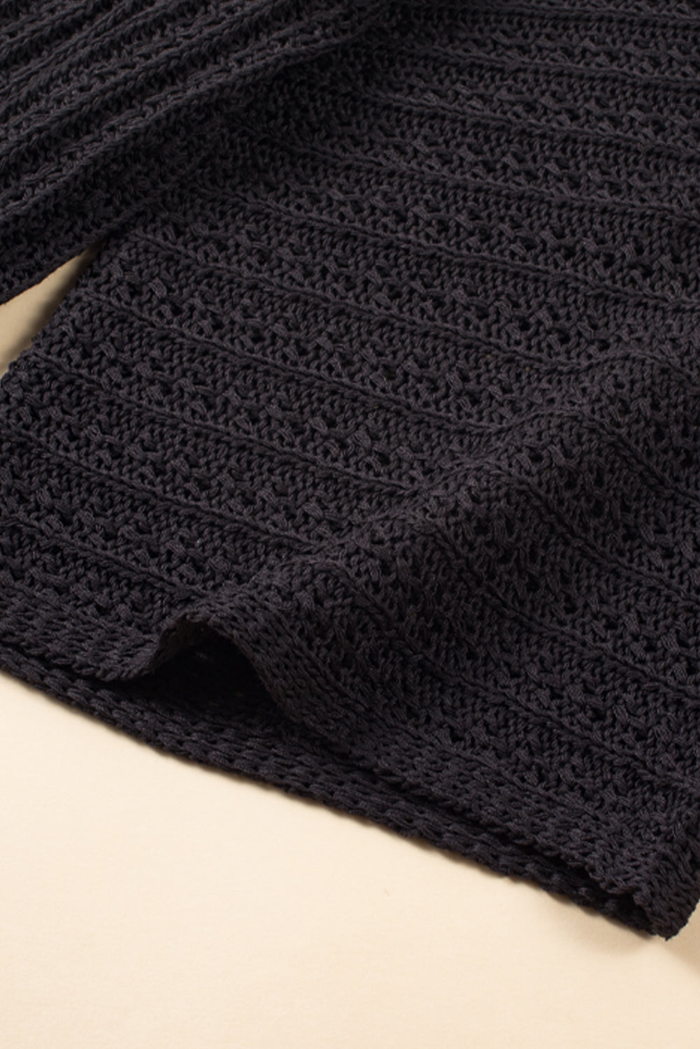 Schwarze strickjacke mit ausgehöhlten armbändern und ärmeln