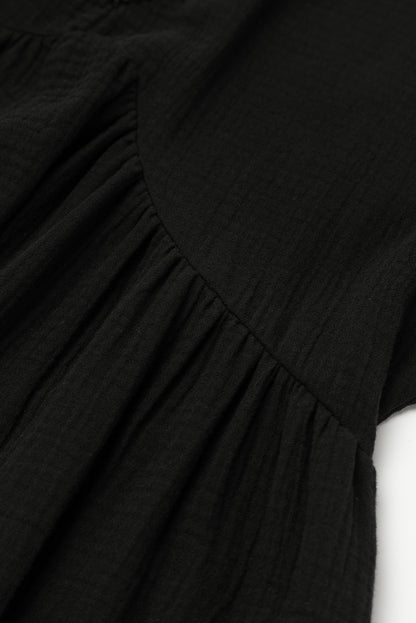 Schwarzes gefaltetes minikleid mit kurzen ärmeln und v-ausschnitt