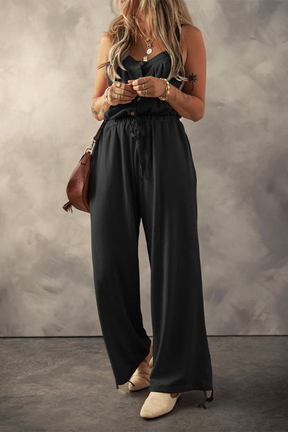 Schwarzer jumpsuit mit geknoteten trägern und strukturiertem kordelzug