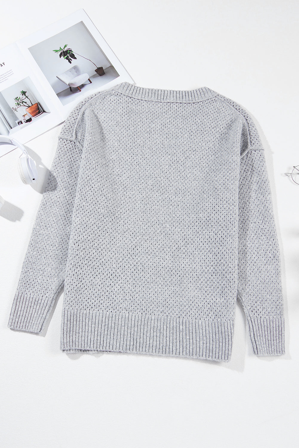 Hellgrauer lockerer pullover mit v-ausschnitt und tropfenschulter
