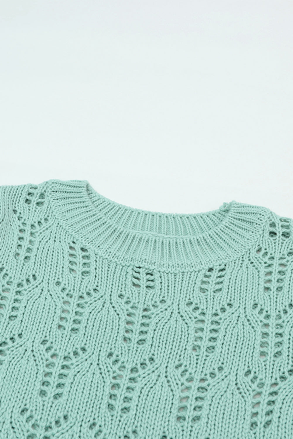 Grüner pointelle-pullover aus transparentem strick