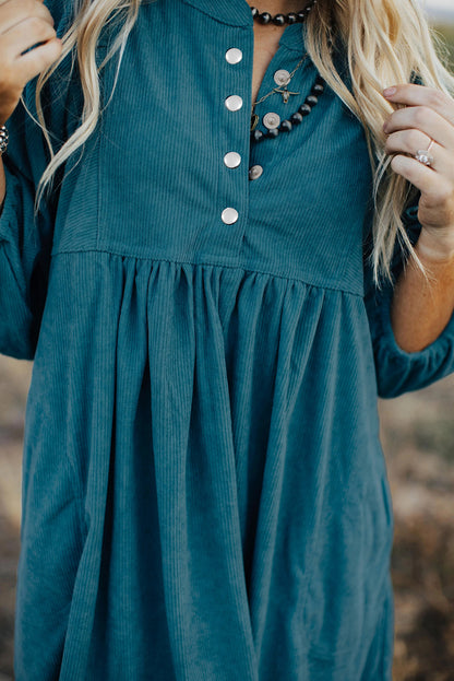 Blaues cord-knopf-kleid mit empire-taille und armband-ärmeln