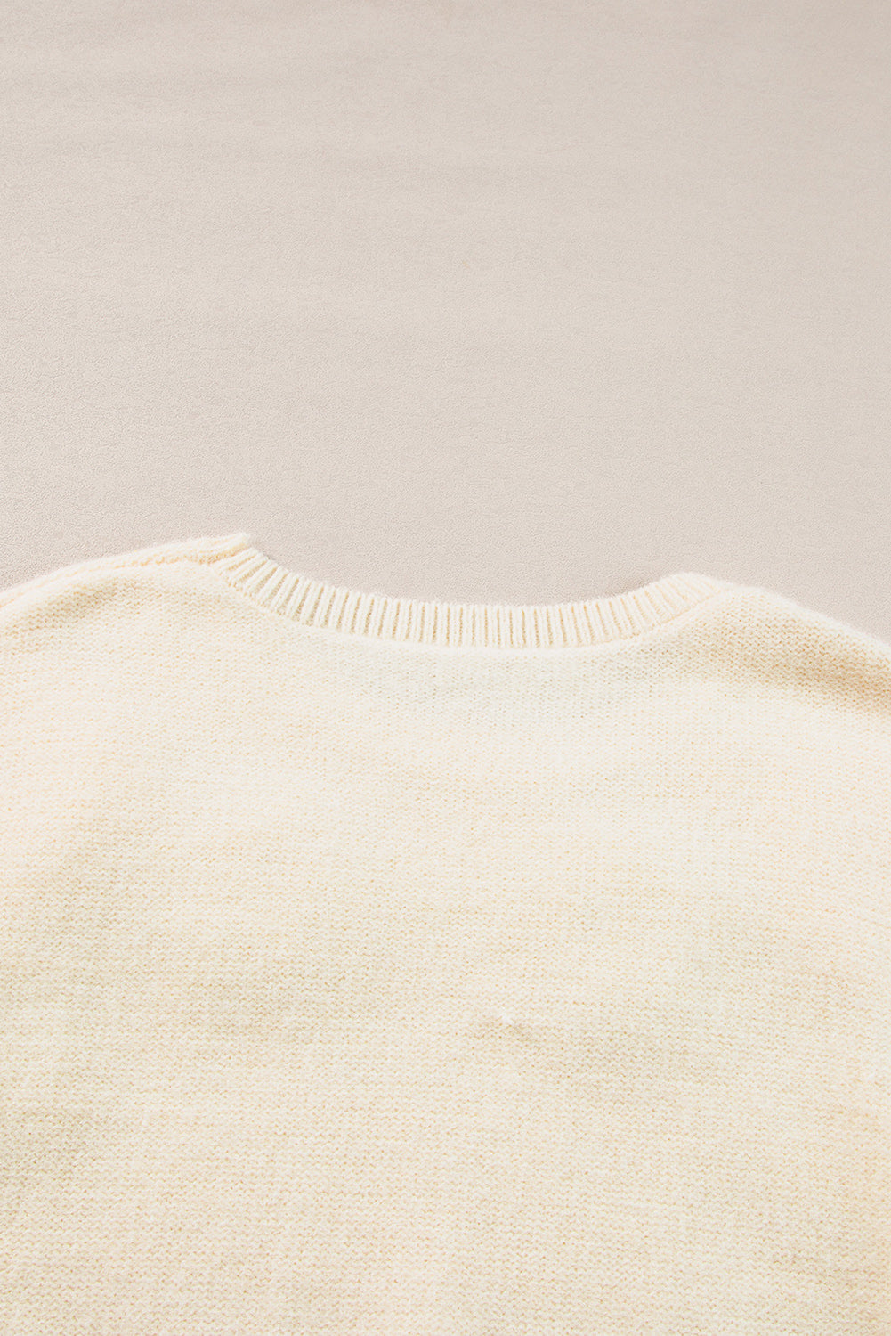 Beige gestrickter pullover mit blumenmuster und geripptem rand